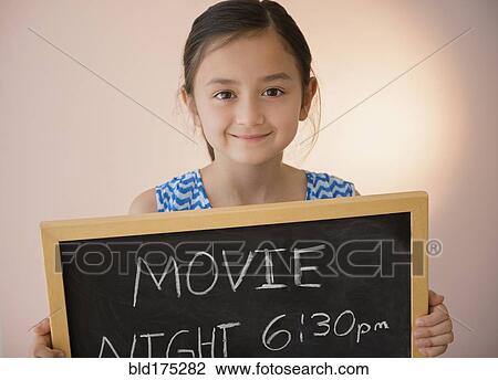 Girl holding chalkboard movie night sign View Large Photo Image Stock Image - Girl holding chalkboard movie night sign. Fotosearch