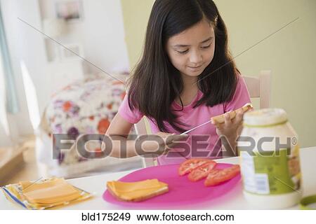 Stock Photo - Girl making lunch sandwiches. Fotosearch