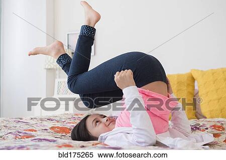 Stock Photography - Girl playing on bed. Fotosearch