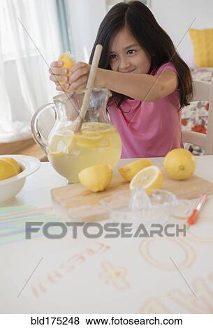 Girl squeezing lemons for lemonade View Large Photo Image Stock Photo - Girl squeezing lemons for lemonade. Fotosearch