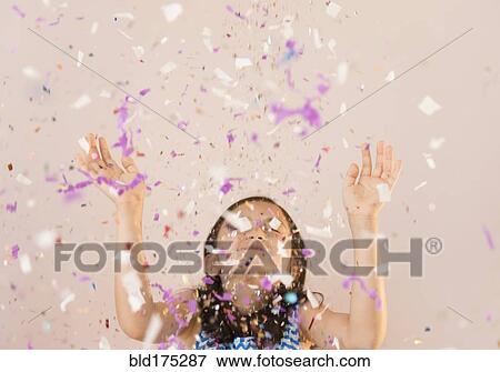 Stock Photo - Girl tossing confetti in air. Fotosearch