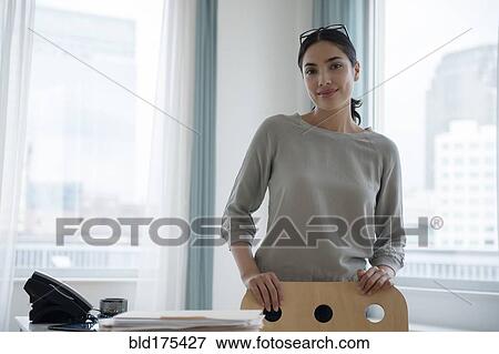 Stock Photo - Hispanic businesswoman smiling in office. Fotosearch