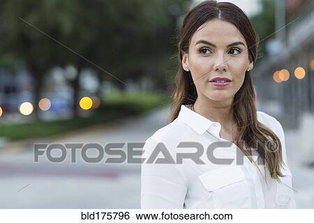 Stock Photograph - Hispanic businesswoman smiling outdoors. Fotosearch