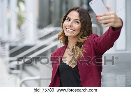 Hispanic businesswoman taking selfie outdoors View Large Photo Image Stock Photo - Hispanic businesswoman taking selfie outdoors. Fotosearch