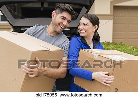 Hispanic couple carrying cardboard boxes near car View Large Photo Image Stock Photography - Hispanic couple carrying cardboard boxes near car. Fotosearch