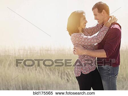 Stock Photography - Hispanic couple hugging outdoors. Fotosearch