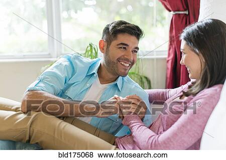 Stock Photo - Hispanic couple relaxing on sofa. Fotosearch