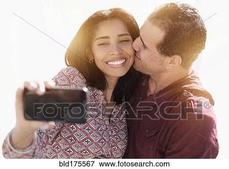 Hispanic couple taking selfie outdoors View Large Photo Image Stock Photo - Hispanic couple taking selfie outdoors. Fotosearch