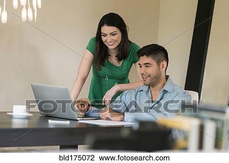 Hispanic couple using laptop at table View Large Photo Image Stock Image - Hispanic couple using laptop at table. Fotosearch