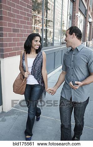 Stock Image - Hispanic couple walking outdoors. Fotosearch
