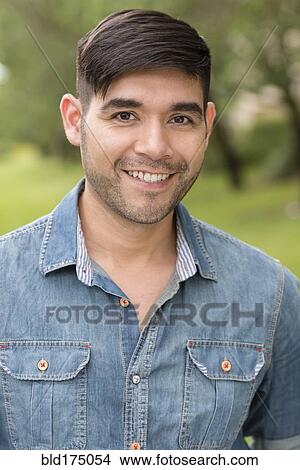 Picture - Hispanic man smiling outdoors. Fotosearch