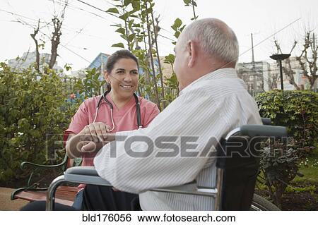 Hispanic nurse comforting patient in wheelchair View Large Photo Image Stock Photograph - Hispanic nurse comforting patient in wheelchair. Fotosearch