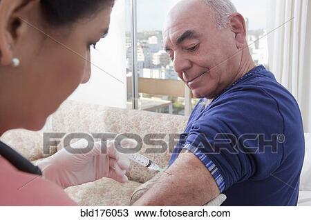 Stock Image - Hispanic nurse giving patient injection. Fotosearch