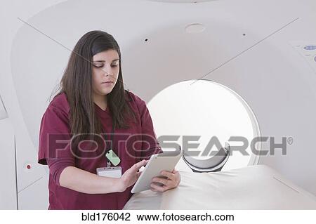 Hispanic nurse using digital tablet in MRI room View Large Photo Image Stock Image - Hispanic nurse using digital tablet in MRI room. Fotosearch