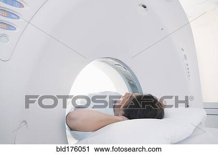 Stock Image - Hispanic patient laying in MRI machine. Fotosearch