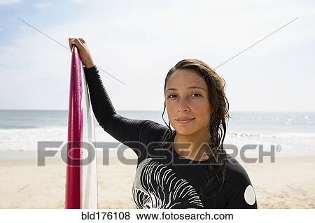 Hispanic surfer holding surfboard on beach View Large Photo Image Stock Photo - Hispanic surfer holding surfboard on beach. Fotosearch