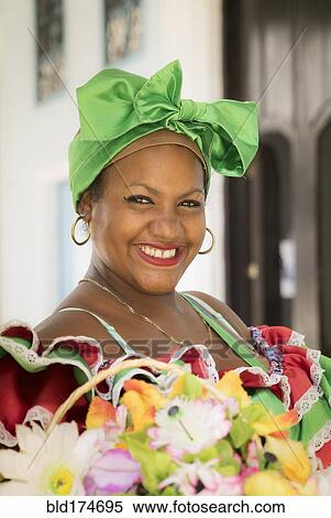 Stock Photography - Hispanic woman carrying basket of flowers. Fotosearch