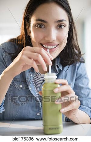 Hispanic woman drinking green juice View Large Photo Image Stock Photograph - Hispanic woman drinking green juice. Fotosearch