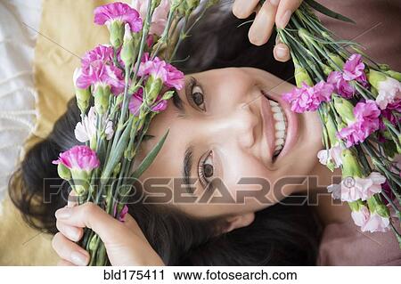Stock Image - Hispanic woman holding flowers. Fotosearch