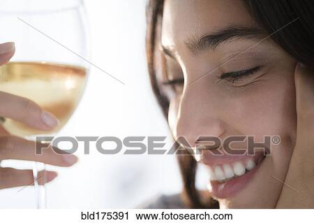 Stock Image - Hispanic woman holding glass of wine. Fotosearch