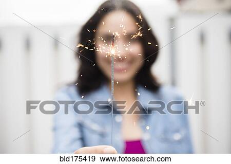Hispanic woman holding sparkler View Large Photo Image Stock Photo - Hispanic woman holding sparkler. Fotosearch