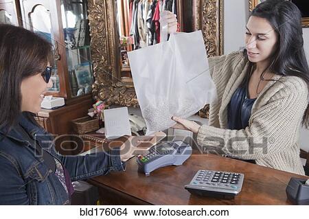Hispanic woman paying with cell phone View Large Photo Image Picture - Hispanic woman paying with cell phone. Fotosearch