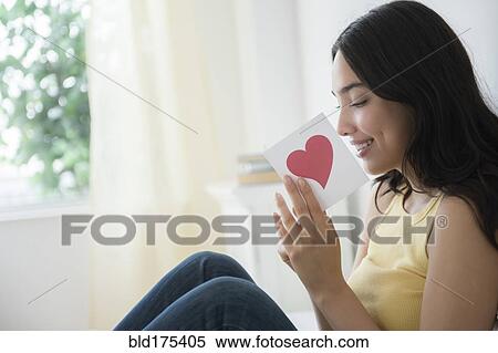 Stock Photography - Hispanic woman reading romantic card. Fotosearch