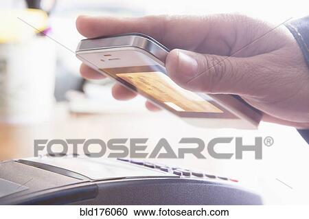 Stock Image - Hispanic woman scanning credit card from cell phone. Fotosearch