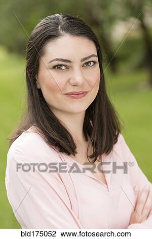 Stock Image - Hispanic woman smiling outdoors. Fotosearch
