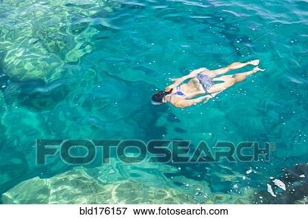 Stock Photo - Hispanic woman swimming in ocean. Fotosearch