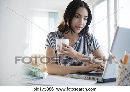 Hispanic woman using laptop at desk View Large Photo Image Stock Photograph - Hispanic woman using laptop at desk. Fotosearch