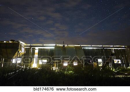 Stock Photograph - Illuminated cabin under morning sky. Fotosearch