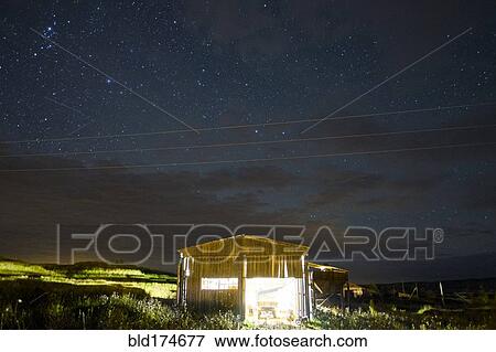 Illuminated cabin under starry night sky View Large Photo Image Stock Photo - Illuminated cabin under starry night sky. Fotosearch