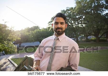 Stock Photo - Indian businessman smiling on steps. Fotosearch