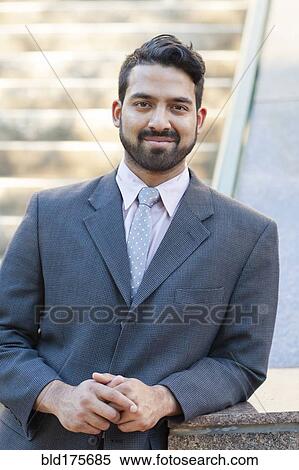 Stock Photography - Indian businessman smiling outdoors. Fotosearch