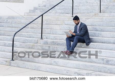Indian businessman using digital tablet on steps View Large Photo Image Stock Image - Indian businessman using digital tablet on steps. Fotosearch