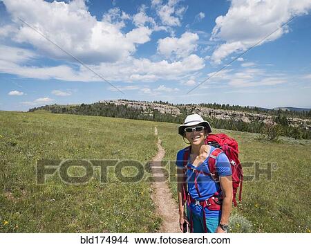 Picture - Japanese hiker smiling on dirt path. Fotosearch