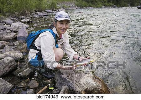 Stock Photo - Japanese woman fishing in river. Fotosearch