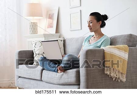 Japanese woman using laptop on sofa View Large Photo Image Stock Image - Japanese woman using laptop on sofa. Fotosearch