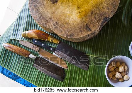 Knives, cutting board and banana leaves on counter View Large Photo Image Stock Photography - Knives, cutting board and banana leaves on counter. Fotosearch