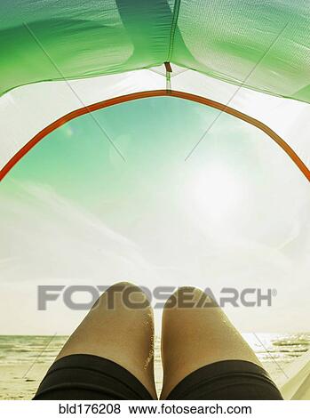 Stock Photo - Legs in camping tent door on beach. Fotosearch