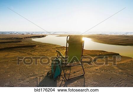 Lounge chair on beach under blue sky View Large Photo Image Picture - Lounge chair on beach under blue sky. Fotosearch