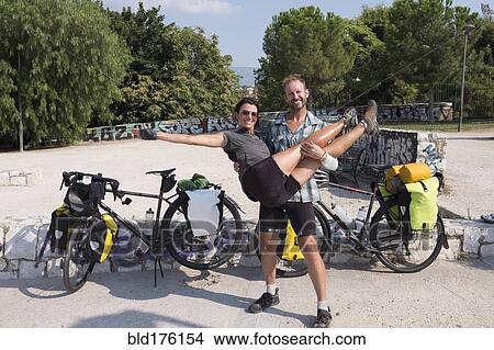 Picture - Man carrying girlfriend on bicycle journey. Fotosearch