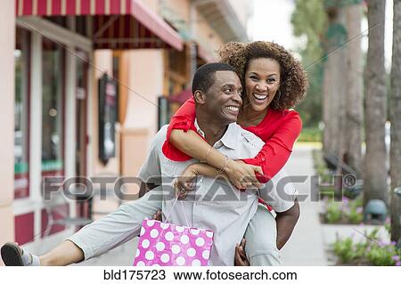 Man carrying girlfriend piggyback outdoors View Large Photo Image Stock Image - Man carrying girlfriend piggyback outdoors. Fotosearch