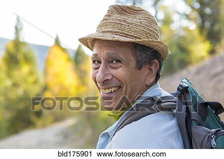 Stock Image - Man exploring autumn forest. Fotosearch