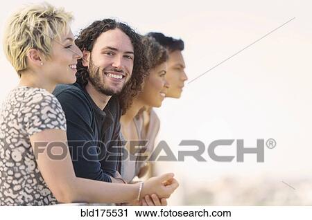 Man smiling with friends outdoors View Large Photo Image Stock Image - Man smiling with friends outdoors. Fotosearch