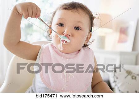 Mixed race baby girl eating yogurt View Large Photo Image Stock Image - Mixed race baby girl eating yogurt. Fotosearch