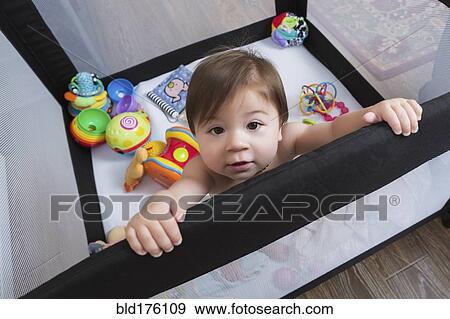 Mixed race baby girl standing in playpen View Large Photo Image Stock Photo - Mixed race baby girl standing in playpen. Fotosearch
