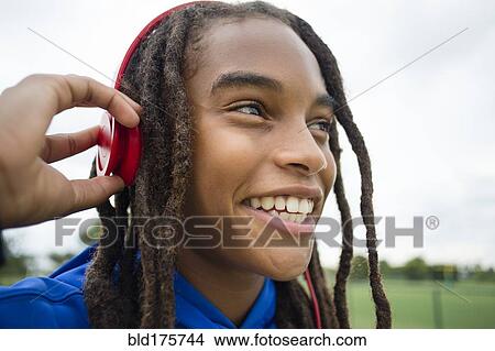 Mixed race boy listening to headphones outdoors View Large Photo Image Picture - Mixed race boy listening to headphones outdoors. Fotosearch