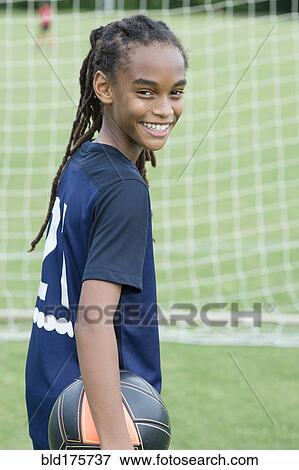 Stock Photo - Mixed race boy playing soccer. Fotosearch